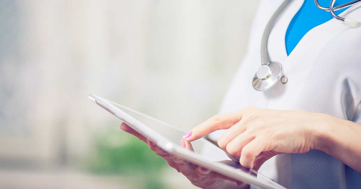 A nurse doing her continuing education units on an ipad.